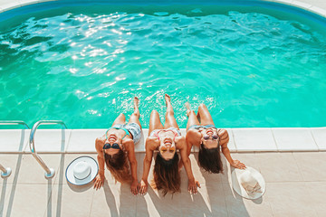 Three girls relaxing and having fun by the pool 