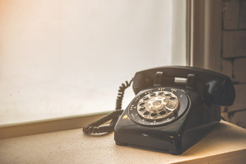Old black phone with dust and scratches, retro style concept 