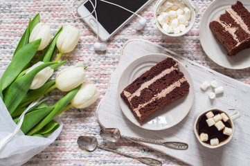 Bouquet of white tulips, coffee and chocolate cake