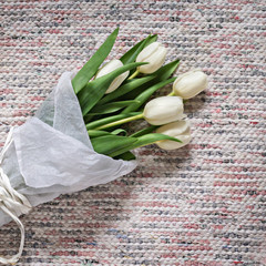 Bouquet of white tulips on textile background