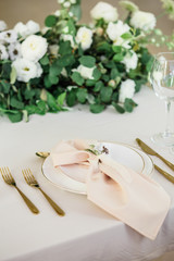 wedding table decorated by plates, knives and forks