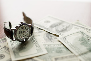 Time to pay - 100 dollars banknote and classic watch with Roman numerals