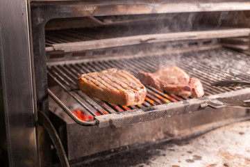 food, craft and delicious concept - cooking steak on a grill