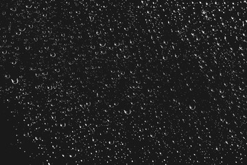 Dirty window glass with drops of rain. Atmospheric monochrome dark background with raindrops. Droplets and stains close up. Detailed transparent texture in macro with copy space. Night rainy weather.