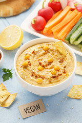 Homemade hummus with olive oil, fresh vegetable sticks and chips