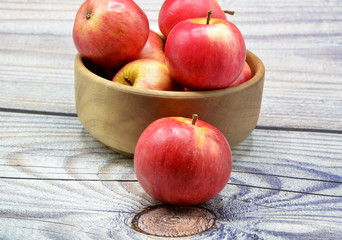 apples in a bowl on wooden table