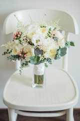 Bridal bouquet. Beautiful of white flowers and greenery, on vintage wooden chair
