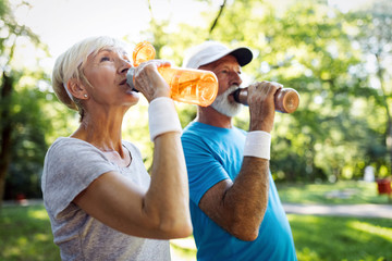 Senior couple staying hydrated after running jogging - Powered by Adobe