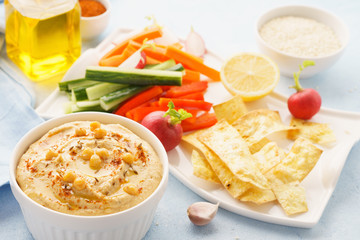 Hummus and variety of vegetable sticks and chips.