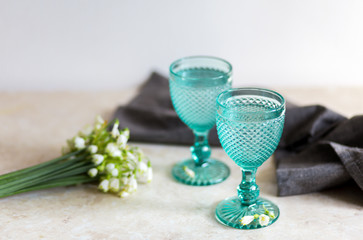 Refhesing drink in blue vintage goblets on the white background with srping flowers.