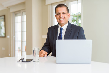 Middle age business man working with computer laptop with a happy and cool smile on face. Lucky person.