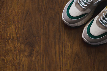 Pair of sport shoes on wooden background. New sneakers and space for ad text.