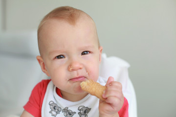 Cute little boy eating his first baby food