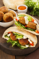 Falafel and fresh vegetables in pita bread with sauce.
