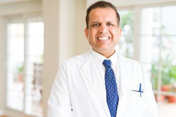 Fototapeta premium Middle age man wearing white medical coat and smiling