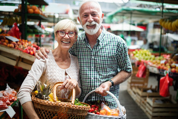 Senior shopping couple with basket on the market. Healthy diet.