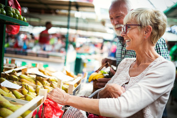 Only the best fruits and vegetables. Beautiful senior couple buying fresh food on market