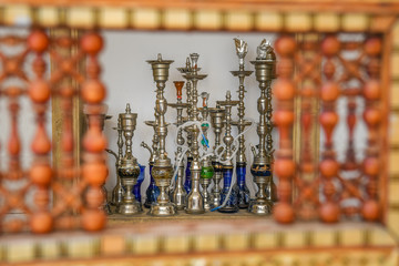 Shisha smoking pipes through oriental red wooden hand crafted wall window