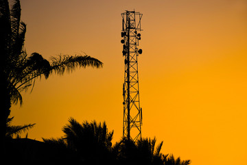 Silhouette of telecommunication antenna cellular tower for mobile signal network with beautiful...