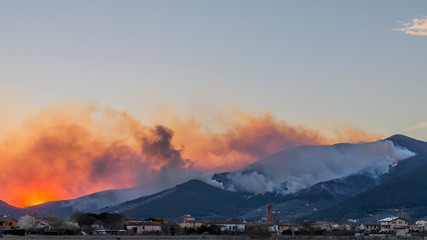 Dramatic sunset on Monte Pisano during a vast arson that destroyed the vegetation, Tuscany, Italy