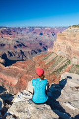 Young woman sitting on the edge of Grand Canyon enjoying the view. Grand Canyon hiker woman...
