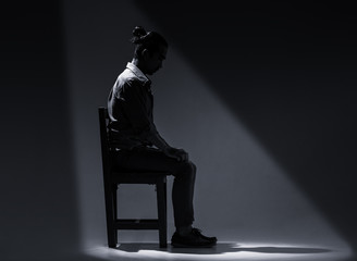 An Asian man is suffering from depression in darkness.