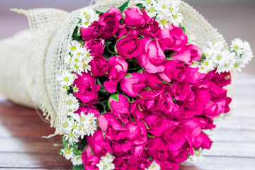 The view of the pink rose bouquet close-up,arranged on wooden table,be used to display,to various festivals(Valentine,wedding,New Year's party,birthday party)or to decorate in Restaurant,coffee shop