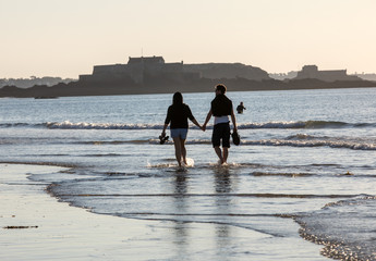 Romantic walk of a couple in love on the beach in Saint Malo. Brittany, France