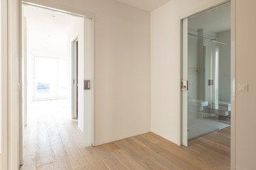 Corridor with open room doors and modern bathroom