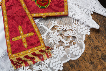 19th century red damask chalice veil and maniple on a white lace catholic priest surplice