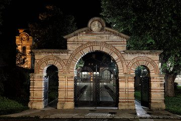 Fototapeta premium Medieval Ornamental Stone And Metal Gate With Metal Orthodox Crosses At Night 