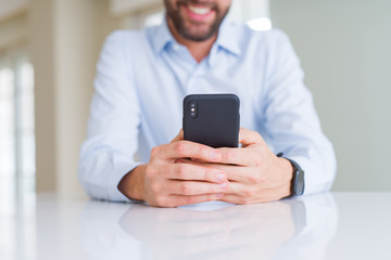 Close up of man hands using smartphone and smiling