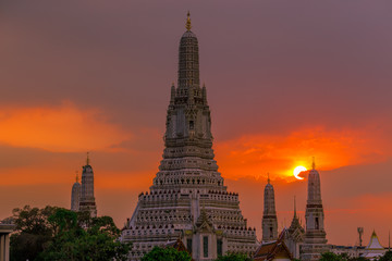 Obraz premium Twilight wallpaper in the evening,the sun going back to the horizon,Wat Arun Ratchawaramaram is a temple along the ChaoPhraya River is an important place and a beautiful tourist destination in Bangkok