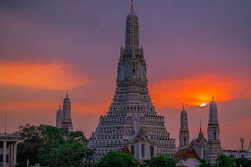 Obraz premium Twilight wallpaper in the evening,the sun going back to the horizon,Wat Arun Ratchawaramaram is a temple along the ChaoPhraya River is an important place and a beautiful tourist destination in Bangkok