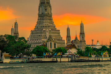 Obraz premium Twilight wallpaper in the evening,the sun going back to the horizon,Wat Arun Ratchawaramaram is a temple along the ChaoPhraya River is an important place and a beautiful tourist destination in Bangkok