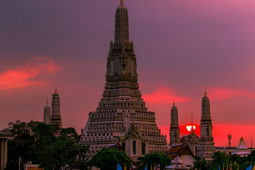 Naklejka premium Twilight wallpaper in the evening,the sun going back to the horizon,Wat Arun Ratchawaramaram is a temple along the ChaoPhraya River is an important place and a beautiful tourist destination in Bangkok