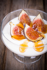 Greek yogurt with figs and honey in a glass serving bowl