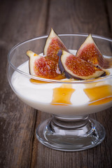 Greek yogurt with figs and honey in a glass serving bowl