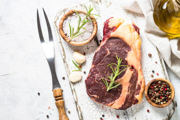 Beef steak ribeye with herbs and spices top view.