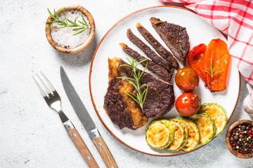 Grilled beef steak with vegetables top view.