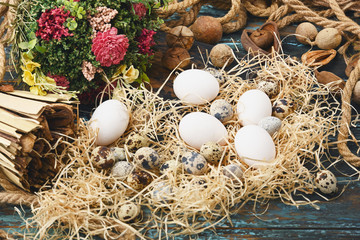 Fototapeta na wymiar White chicken eggs and quail eggs near dry flowers. Eggs For Easter.