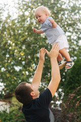 Father play with son outside. Background of green tree
