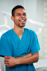 African male dentist looking towards camera and smiling