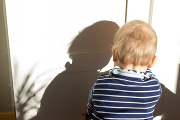 Kind mit Schatten am Schrank