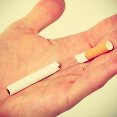 Closeup of broken cigarette on male hand.