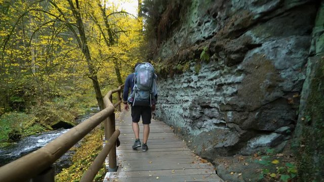 POV of father traveling in the wild nature with son in touristic backpack, Czech Switzerland