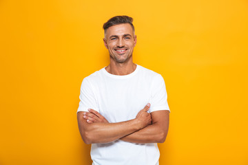 Handsome happy excited man posing isolated over yellow wall background.