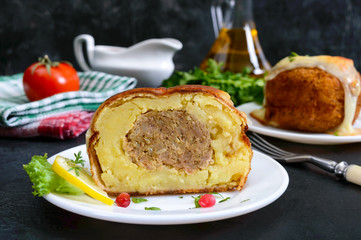 Potato balls with minced meat in deep fat, baked with mozzarella. Cut, close-up