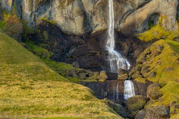 View of a waterfall in Iceland. Water flows from top to bottom.