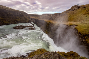 View of a waterfall in Iceland. Water flows from top to bottom.